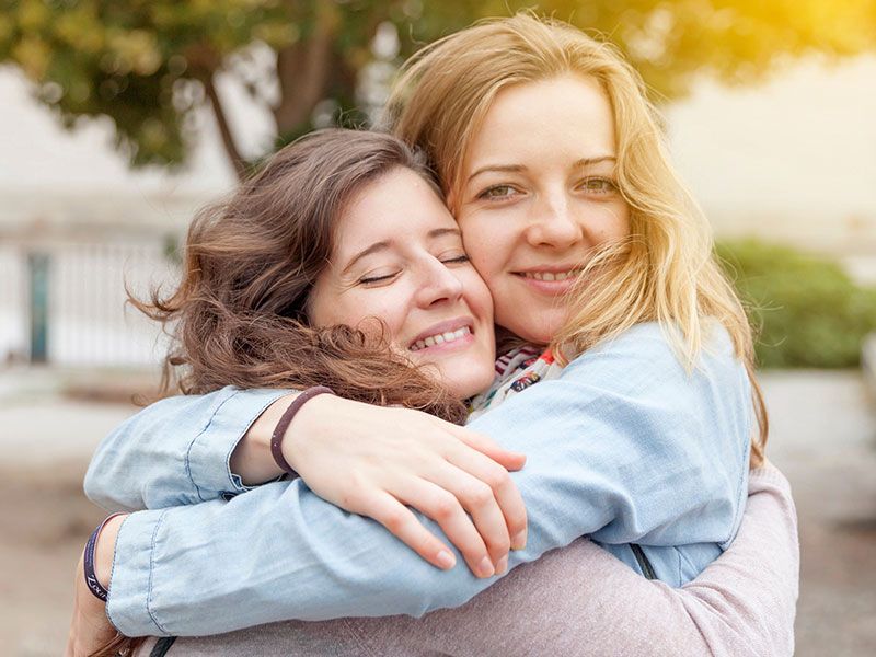 Một cô gái biết nói gì với một người bạn sau khi chia tay, ôm bạn của mình khi cô ấy mỉm cười và ôm lại.