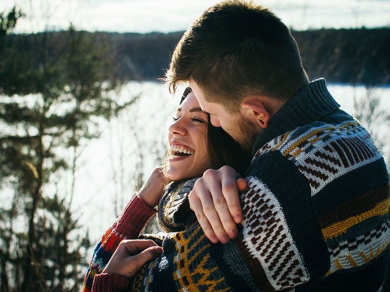 Um casal se abraçando e rindo que aprendeu essas estatísticas de namoro.