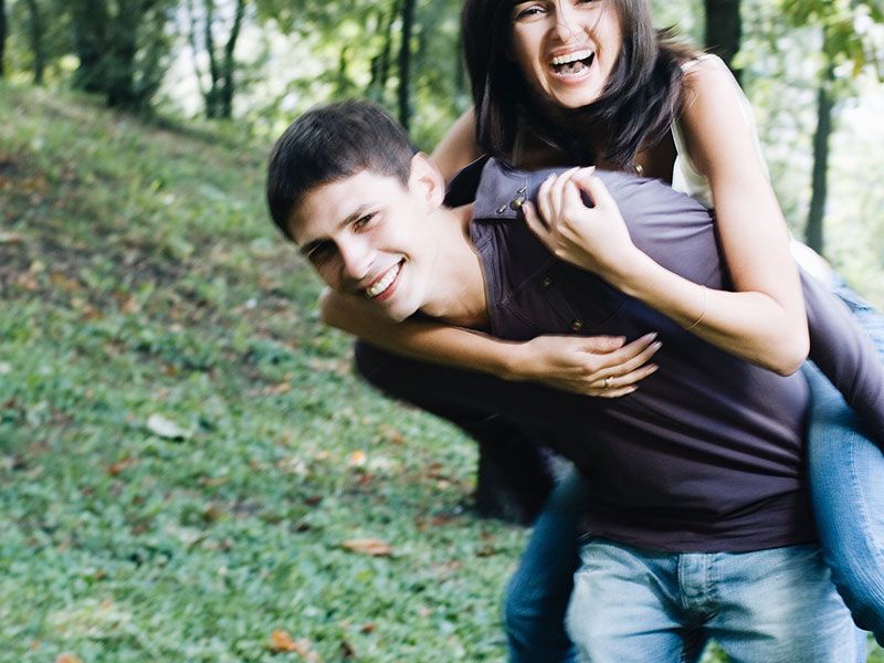 رجل مع صديقته المقربة ، يحملها على ظهره وهم يضحكون ويغيظون بعضهم البعض.