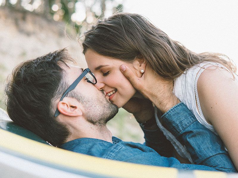 En kvinne som fant ut av dating som betyr å kysse kjæresten sin og smile.