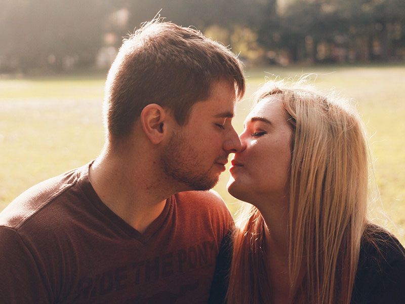 Ein Paar, das kurz vor einem zweiten Date-Kuss steht, die Augen geschlossen und die Lippen fast berührt.