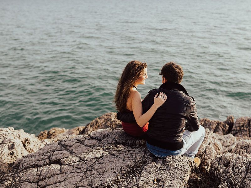 Um cara que aprendeu a pedir para uma garota ser sua namorada conversando com a namorada dele na praia.