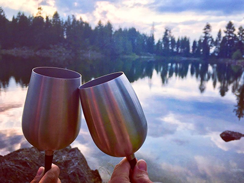 Dva lidé dělají své první rande zábavnější tím, že si dají víno u jezera.