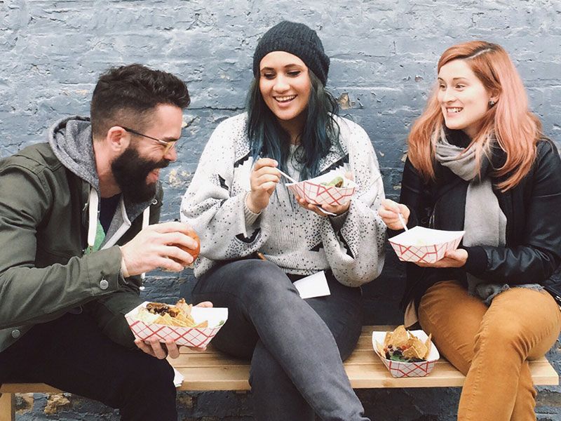 Um grupo que aprendeu a encontrar amigos online rindo e comendo juntos fora.