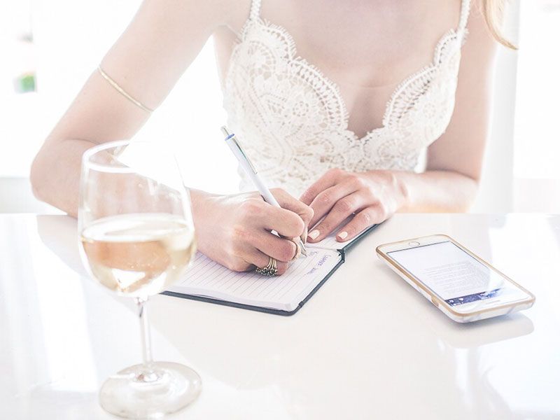 Uma mulher escrevendo uma dessas cartas de amor para ele enquanto bebia uma aula de vinho ao sol.