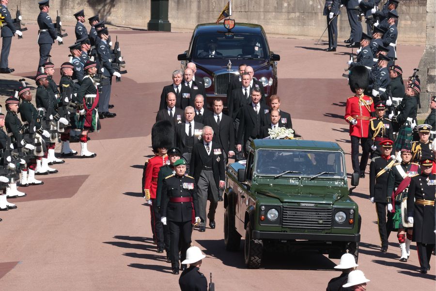 Leden van de koninklijke familie lopen achter een landrover aan met de kist van de Britse prins Philip, hertog van Edinburgh tijdens de ceremoniële begrafenisstoet naar St George
